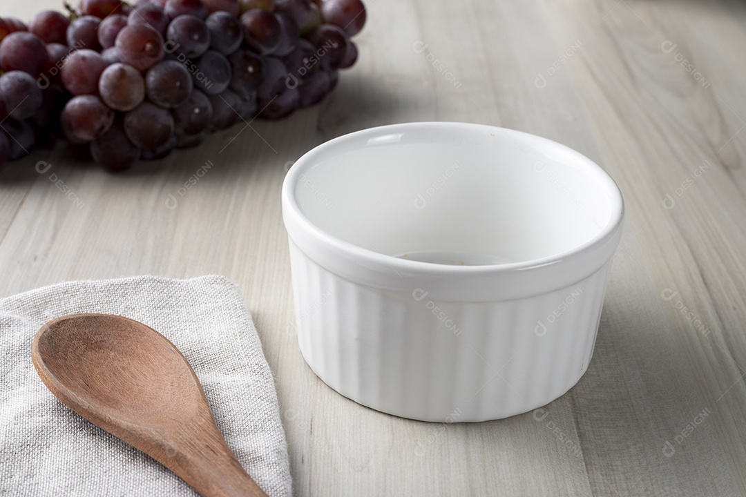 Tigela Com Uvas no Fundo e Uma Colher de Madeiro ao Lado
