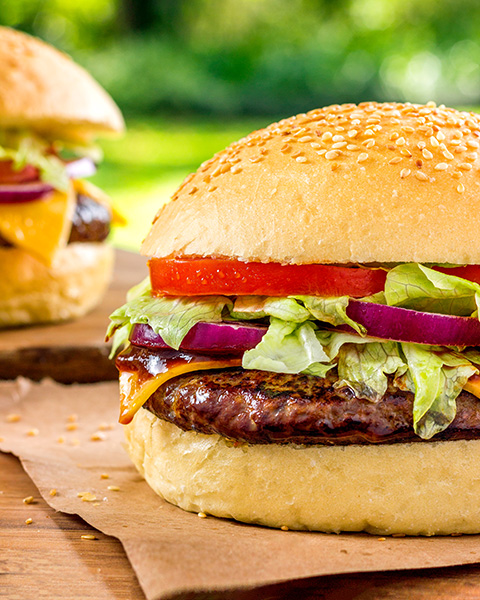 Dois Hambúrgueres Sobre Uma Mesa Com Fundo Verde de Grama