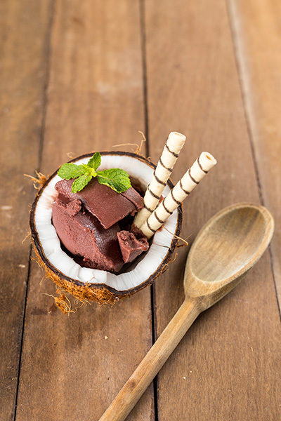 Açaí Na Casca De Coco Com Uma Colher De Pau Do Lado