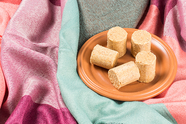 Paçocas Em Um Prato Marrom Sobre Tecidos Coloridos