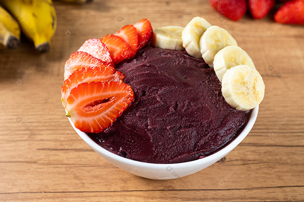 Tigela de Açaí Com Bananas Morangos Sobre uma Mesa de Madeira