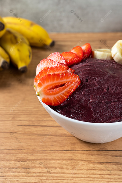 Tigela de Açaí com Bananas e Morangos Sobre uma Mesa de Madeira