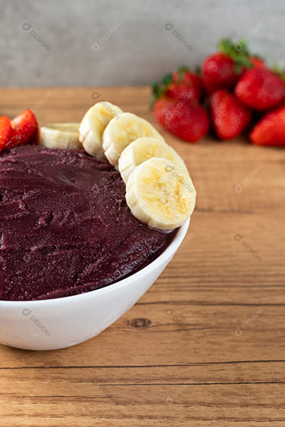 Tigela de Açaí com Bananas e Morangos Sobre uma Mesa de Madeira