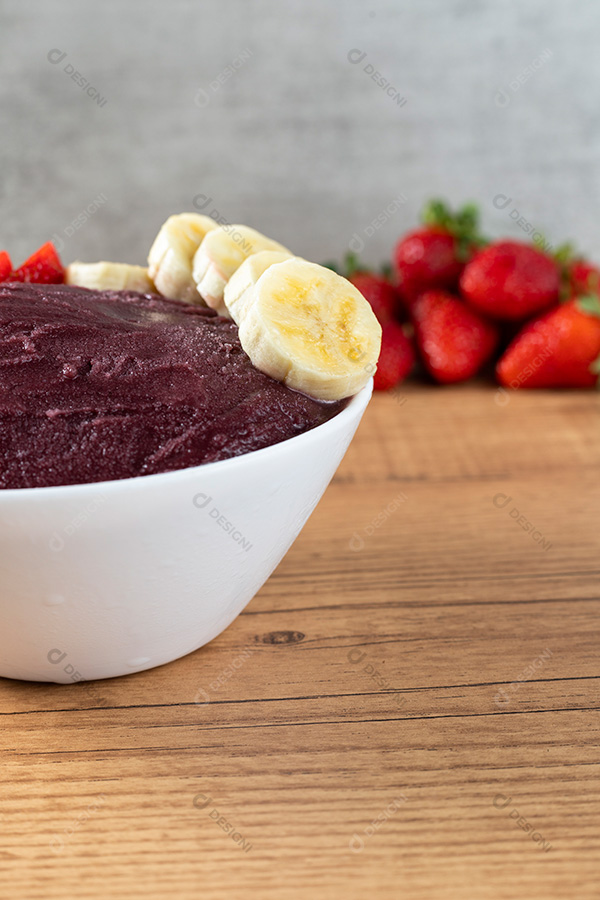 Tigela de Açaí com Bananas e Morangos Sobre uma Mesa de Madeira