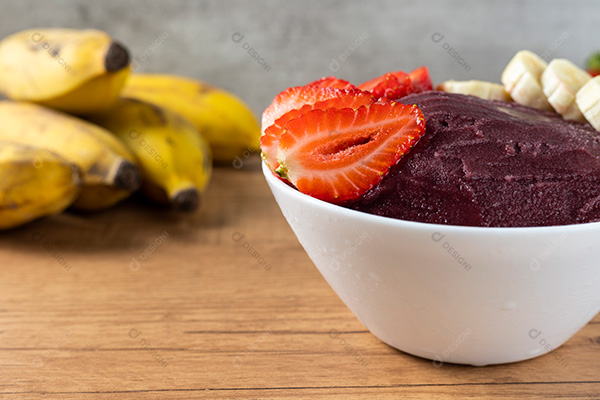 Tigela de Açaí com Bananas e Morangos Sobre uma Mesa de Madeira