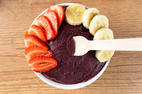 Tigela de Açaí com Bananas e Morangos Sobre uma Mesa de Madeira Visto de Cima