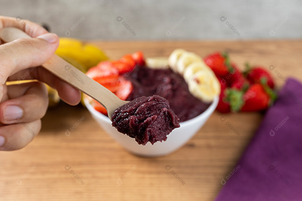Mão Segurando Colher com Açaí Fundo Desfocado
