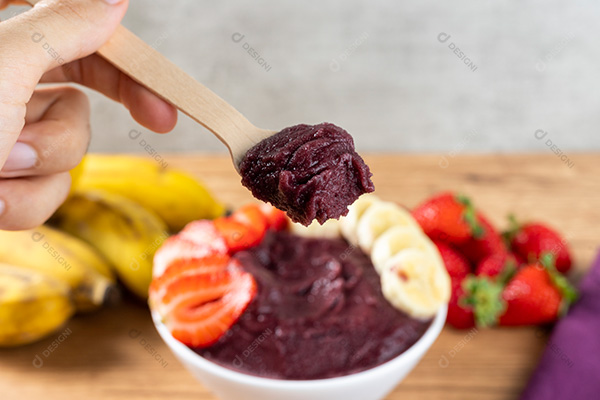 Mão Segurando Colher com Açaí Fundo Desfocado