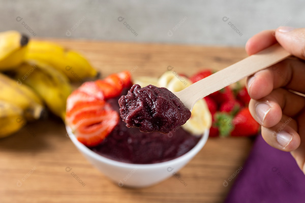 Mão Segurando Colher com Açaí Fundo Desfocado