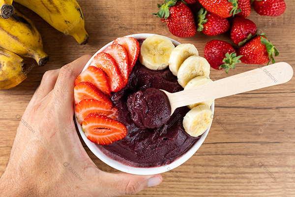 Mão Pegando na Tigela de Açaí com Bananas e Morangos