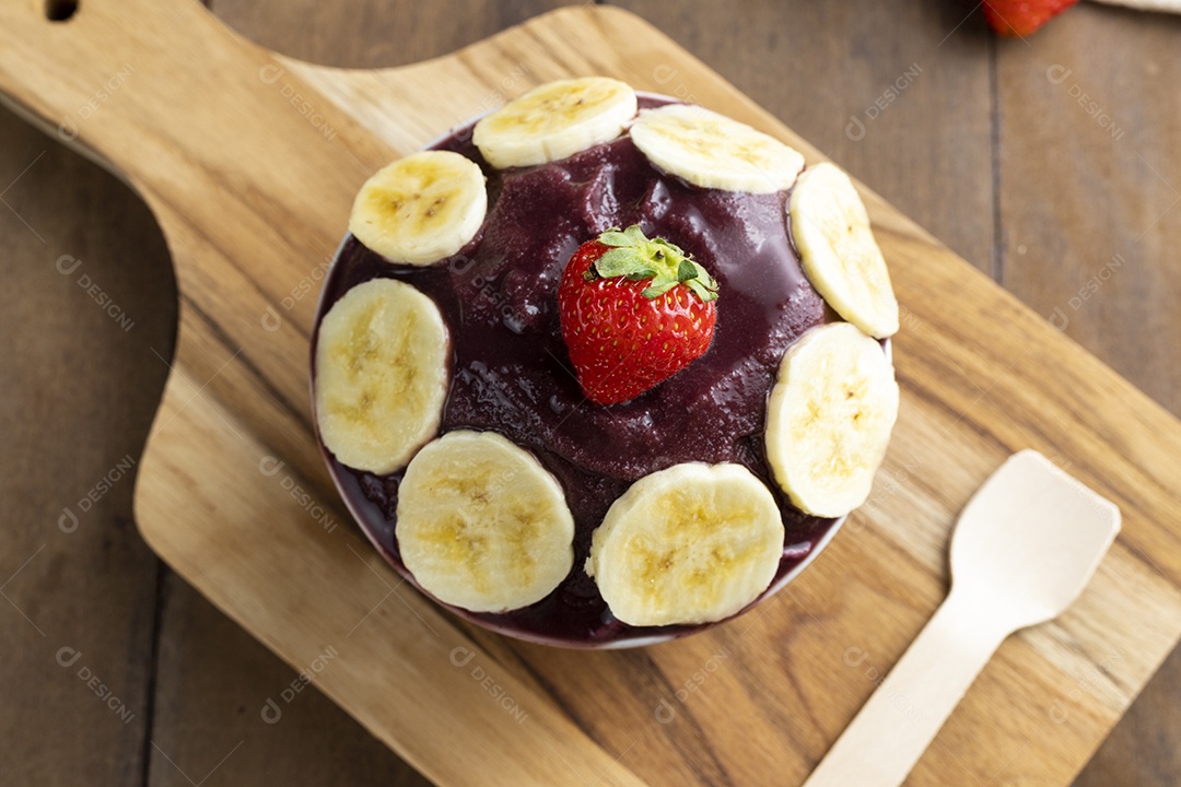 Tigela de Açaí Com Bananas e Um Morango Sobre Tábua de Madeira