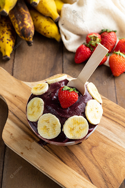 Tigela de Açaí Com Bananas e Um Morango Sobre Tábua de Madeira