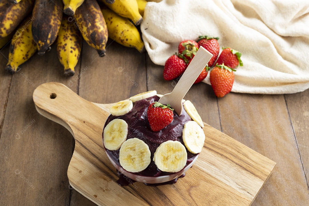 Tigela de Açaí Com Bananas e Um Morango Sobre Tábua de Madeira