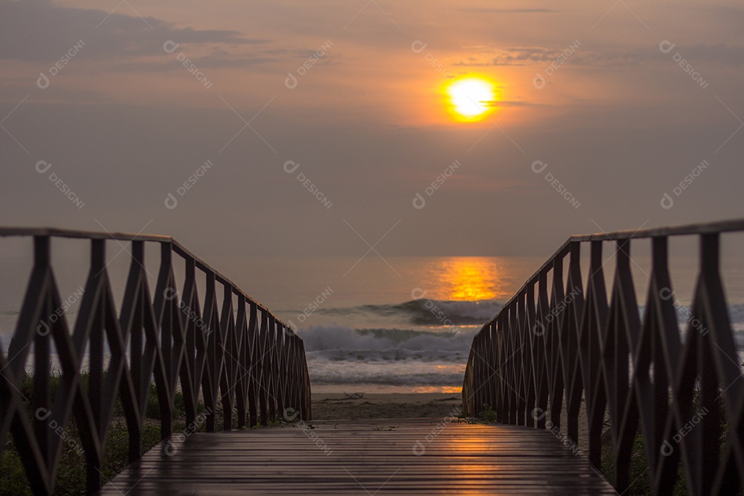Ponte do Convés Sobre a Areia na Praia ao Pôr do Sol