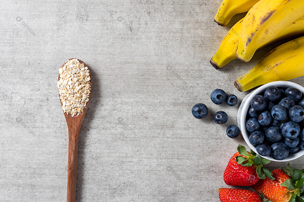 Fundo com Frutas e Uma Colhe de Madeira com Grãos Sobre uma Mesa de Madeira