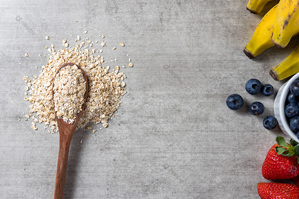 Fundo com Frutas e Uma Colhe de Madeira com Grãos Sobre uma Mesa de Madeira