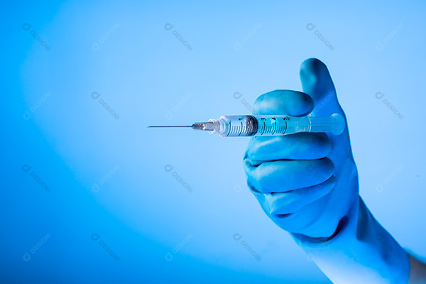 Mão Segurando Seringa Sobre Fundo Azul
