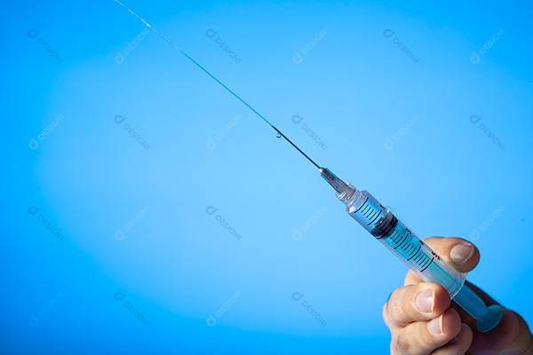 Mão Segurando Seringa Sobre Fundo Azul