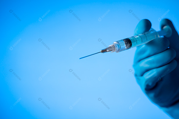 Mão Segurando Seringa Sobre Fundo Azul