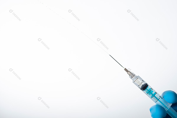 Mão Segurando Seringa Sobre Fundo Azul