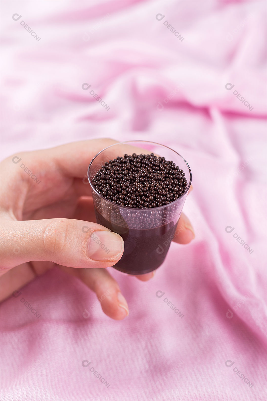 Mão Com Copinho de Brigadeiro de Festa no Fundo Rosa Imagem JPG