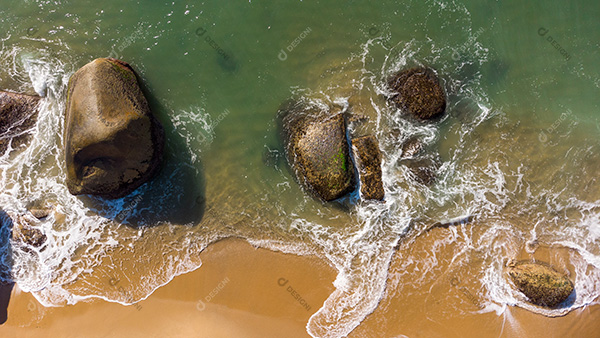 Vista Aérea das Ondas Suaves Batendo nas Rochas