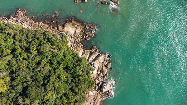 Vista Aérea das Ondas Suaves Batendo nas Rochas