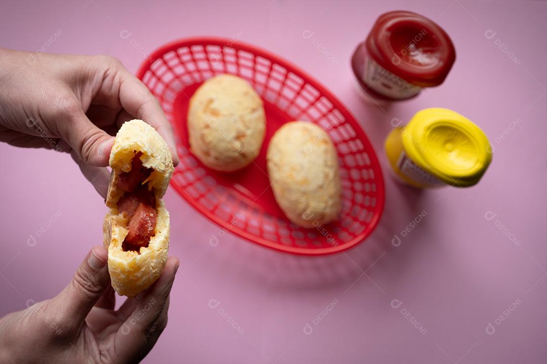 Mão Segurando e Abrindo Pão de Queijo Recheado Imagem JPG