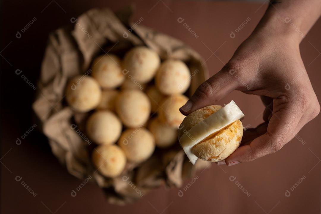 Mão Segurando Pão de Queijo Recheado com Queijo Imagem JPG
