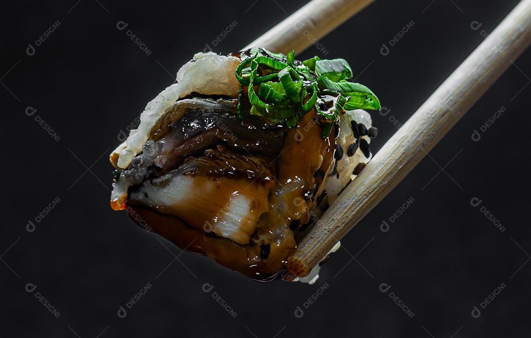 Close-up Feminino Mão Segurando um Pauzinho com Uramaki Pele Filadélfia.