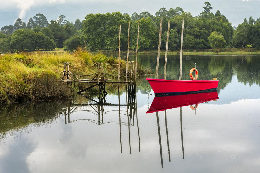 Cais de Madeira Rudimentar Com Barco Vermelho no Rio Com Águas Calmas imagem JPG