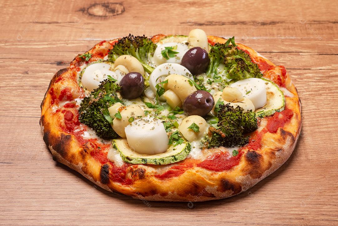 Pizza Vegetariana, Com Brócolis, Palmito, Azeitonas e Abobrinha, Servida Em Uma Rústica Mesa de Madeira