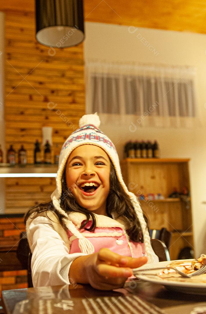 Menina Com Roupas De Frio Comendo e Sorrindo