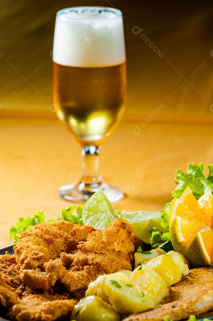 Iscas de Peixe com Condimentos e Cerveja ao Fundo