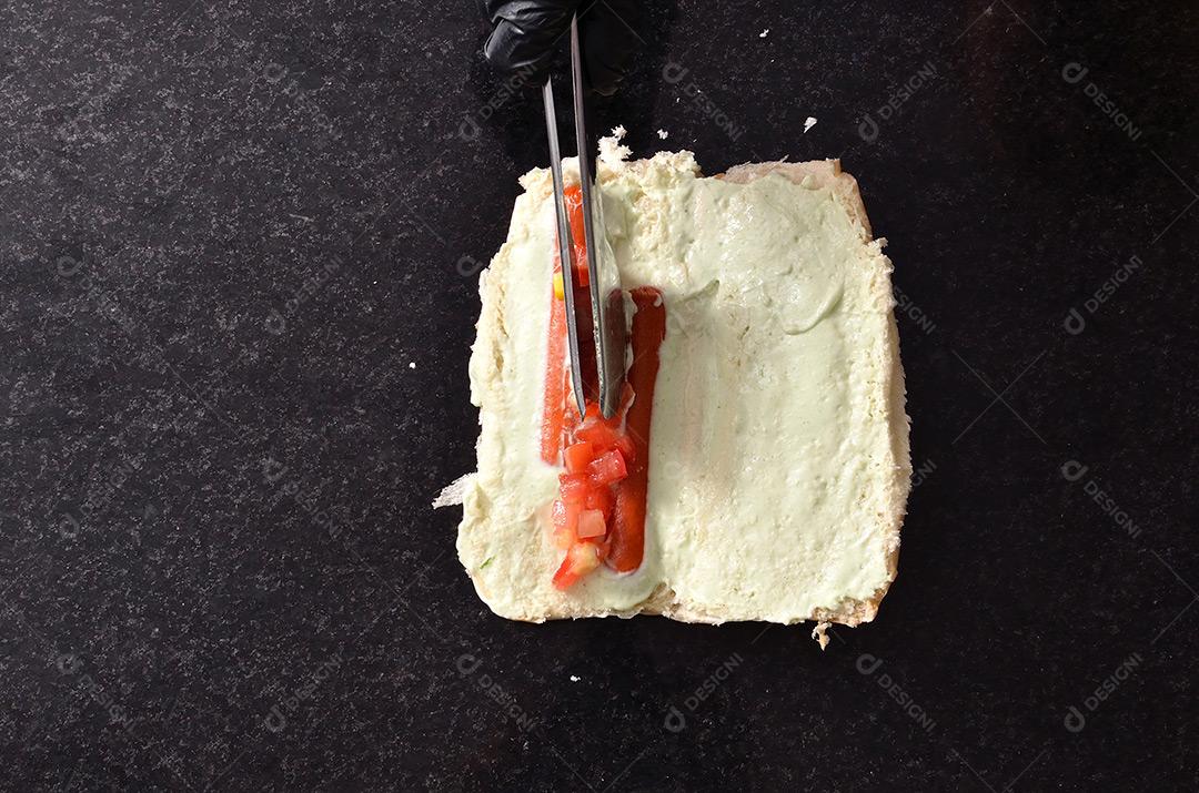 Colocando Tomate Picado No Pâo De Hot Dog Imagem JPG
