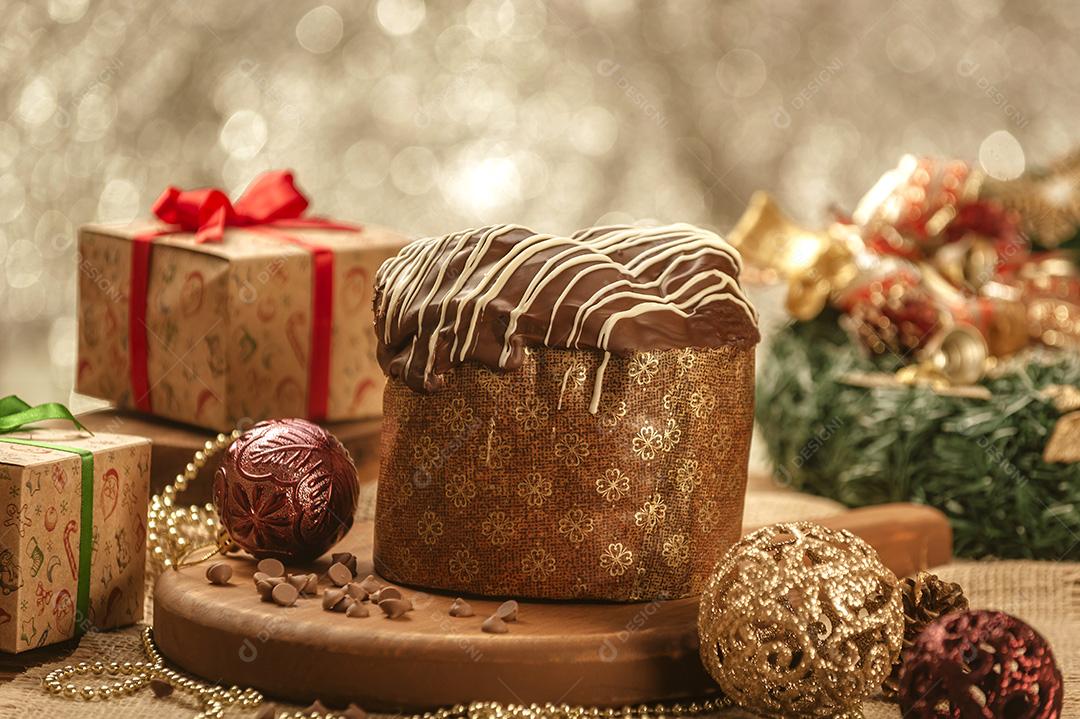 Panetone de Chocolate na Mesa de Madeira Com Enfeites de Natal Imagem JPG