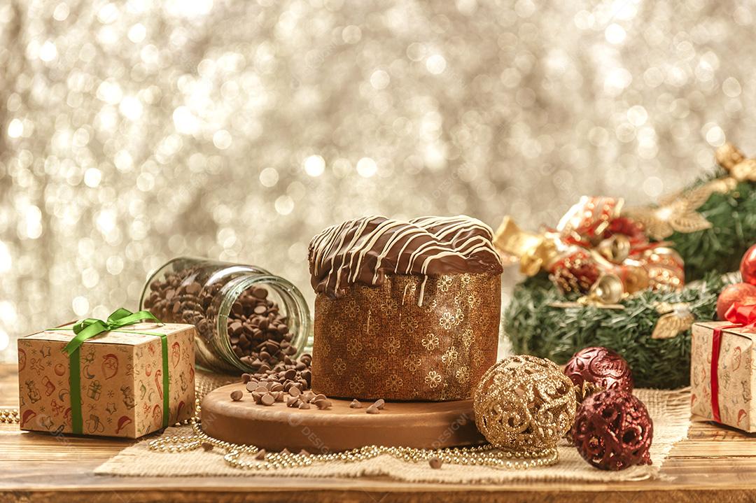 Panetone de Chocolate na Mesa de Madeira Com Enfeites de Natal Imagem JPG
