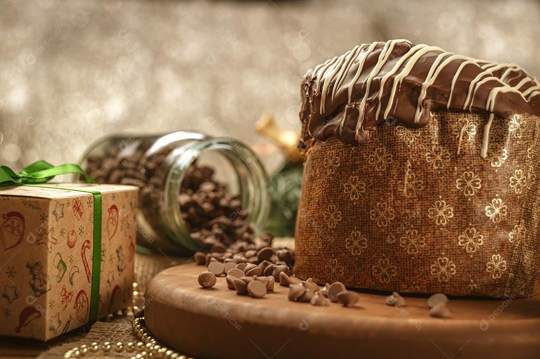 Panetone de Chocolate na Mesa de Madeira Com Enfeites de Natal Imagem JPG