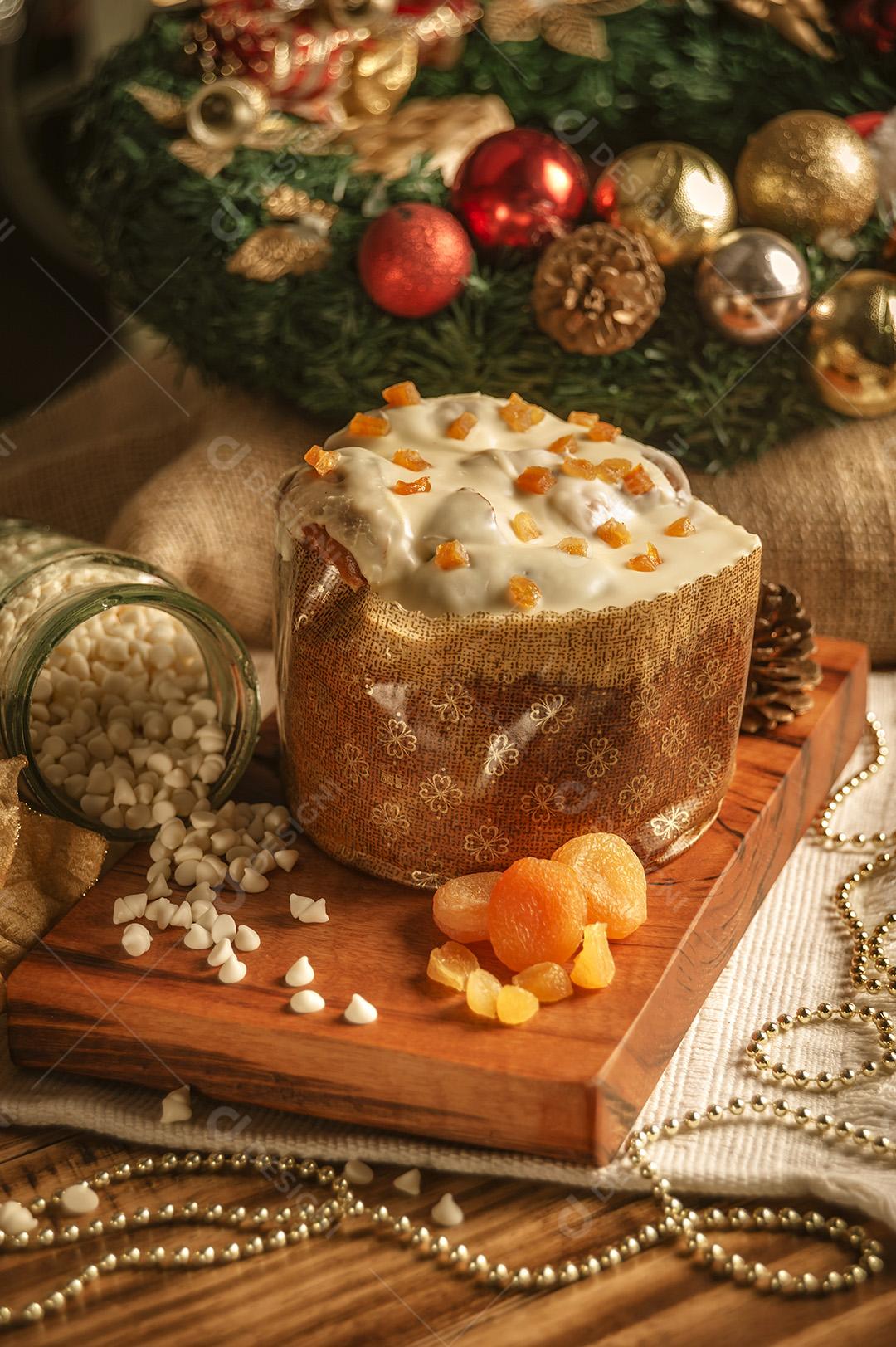 Panetone de Chocolate Branco Com Damasco Seco na Mesa de Madeira Com Enfeites de Natal Imagem JPG
