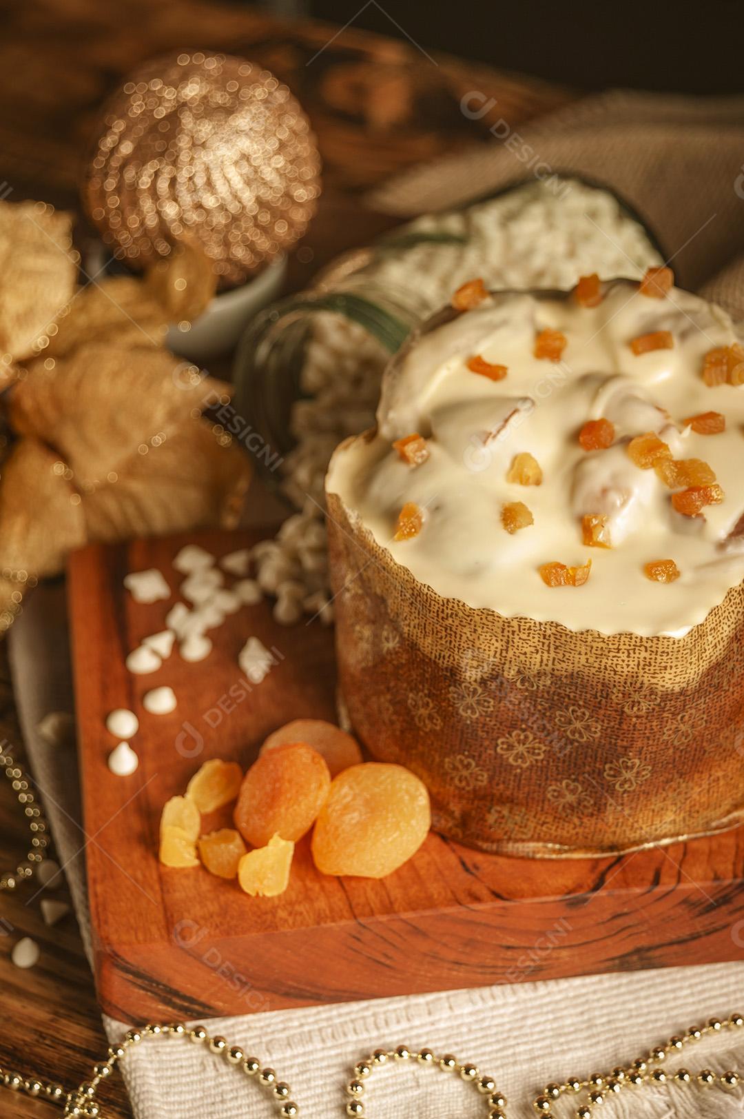 Panetone de Chocolate Branco Com Damasco Seco na Mesa de Madeira Com Enfeites de Natal Imagem JPG