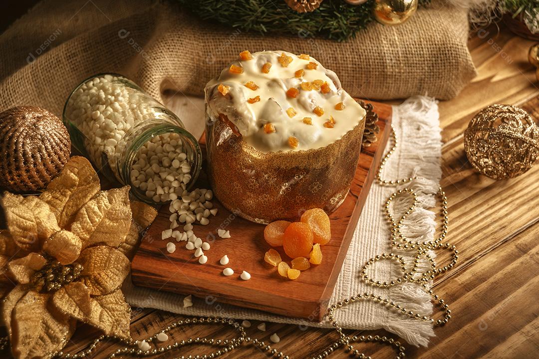 Panetone de Chocolate Branco Com Damasco Seco na Mesa de Madeira Com Enfeites de Natal Imagem JPG