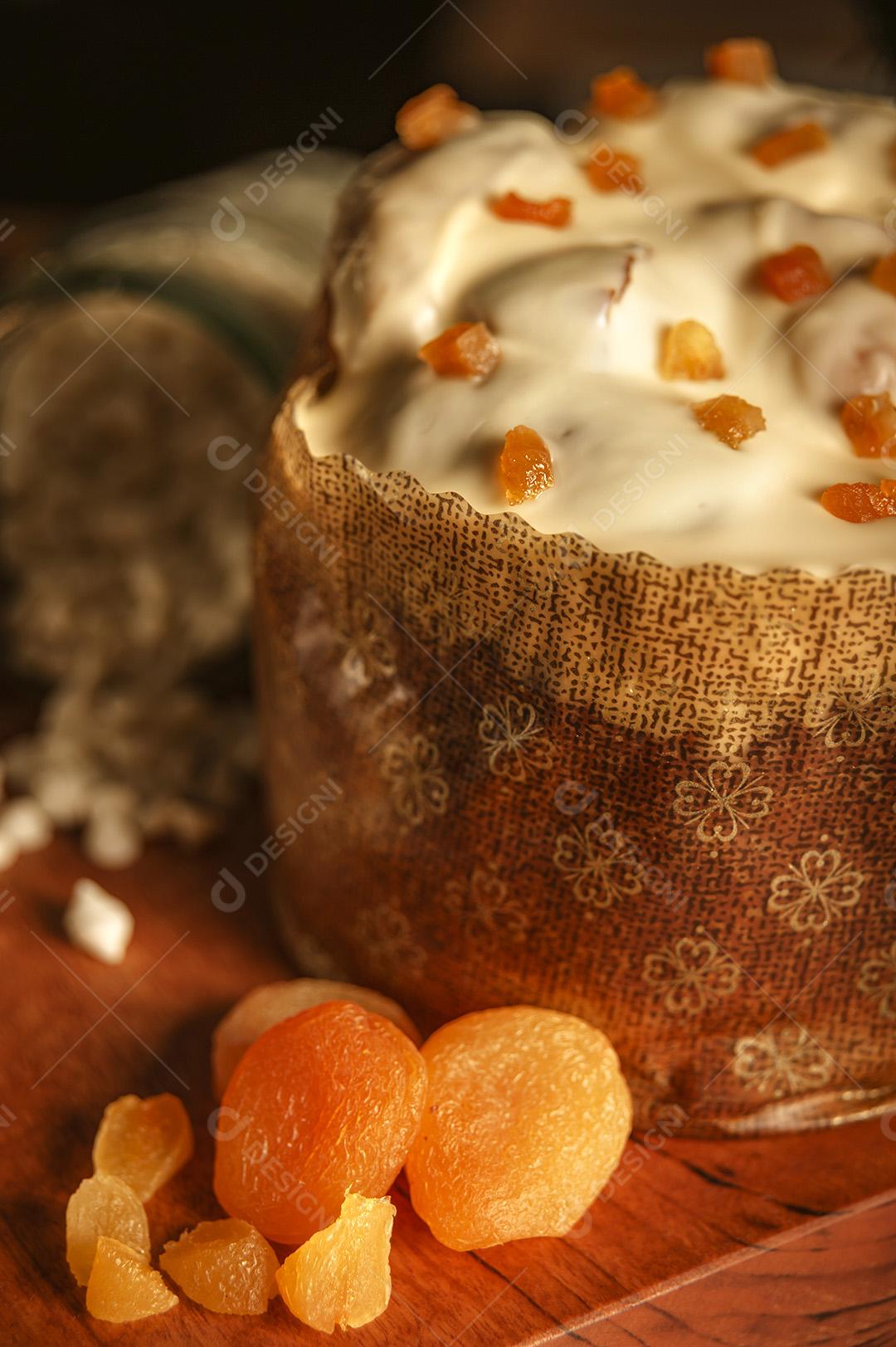 Panetone de Chocolate Branco Com Damasco Seco na Mesa de Madeira Com Enfeites de Natal Imagem JPG