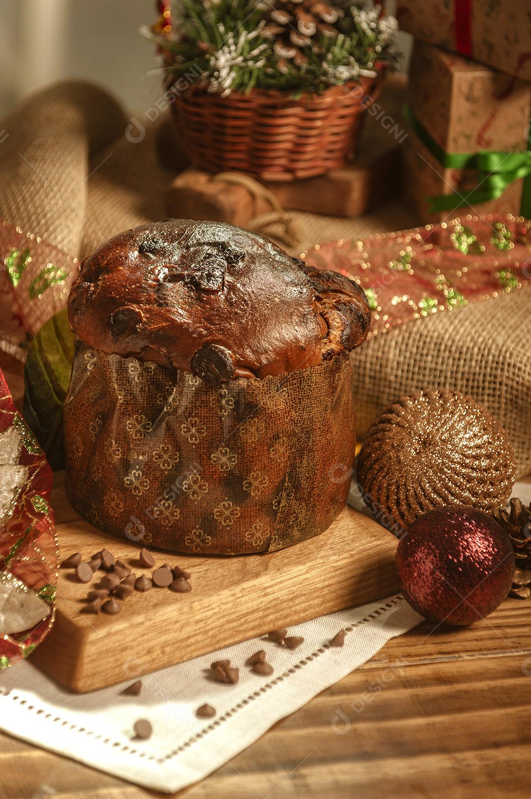 Panetone de Chocolate na Mesa de Madeira Com Enfeites de Natal Imagem JPG