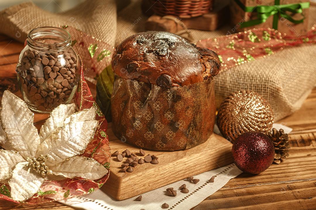 Panetone de Chocolate na Mesa de Madeira Com Enfeites de Natal Imagem JPG