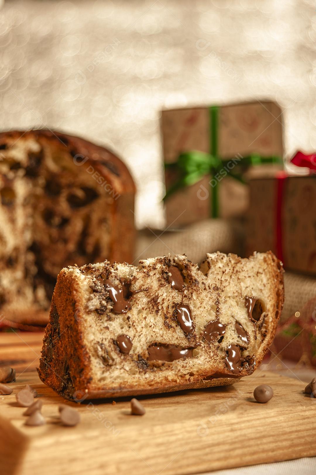 Fatia de Panetone de Chocolate Em Uma Tábua de Madeira Com Enfeites de Natal Imagem JPG