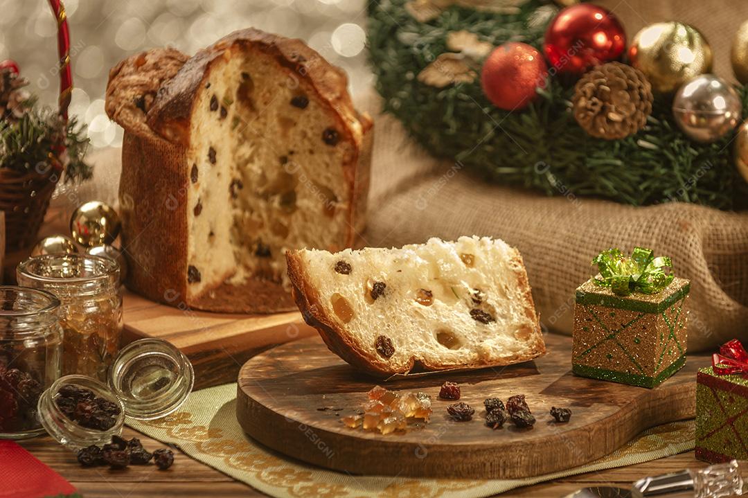 Uma Fatia de Panetone e Cubos de Frutas Cristalizadas Em Uma Tábua de Madeira Com Enfeites de Natal Imagem JPG