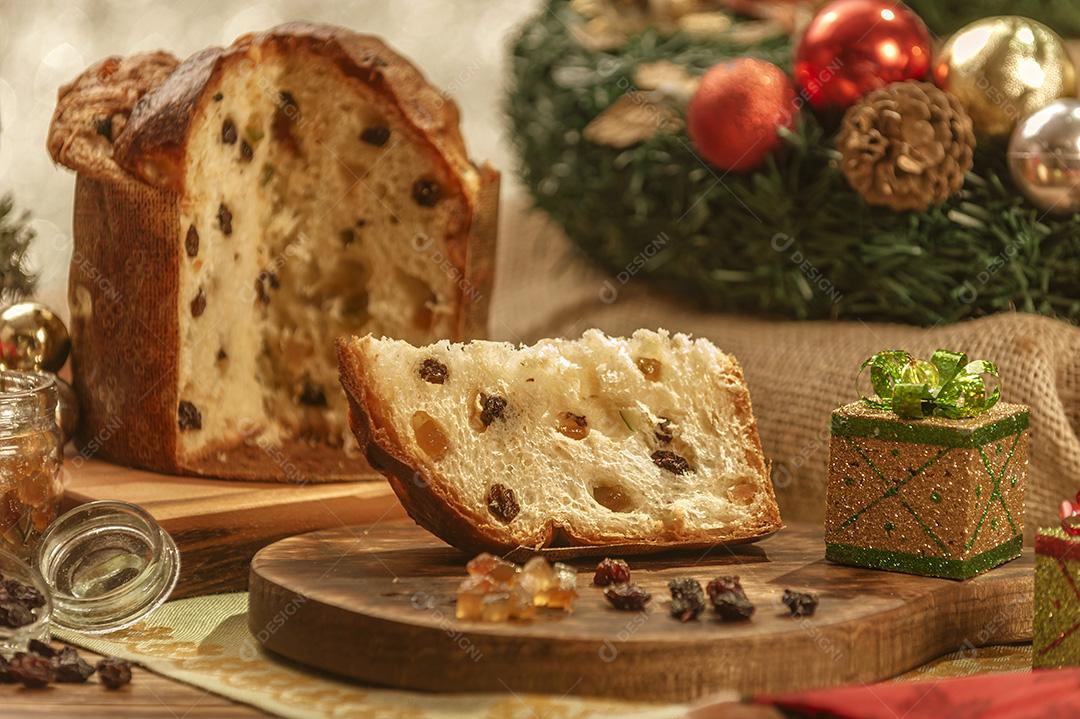 Uma Fatia de Panetone e Cubos de Frutas Cristalizadas Em Uma Tábua de Madeira Com Enfeites de Natal Imagem JPG