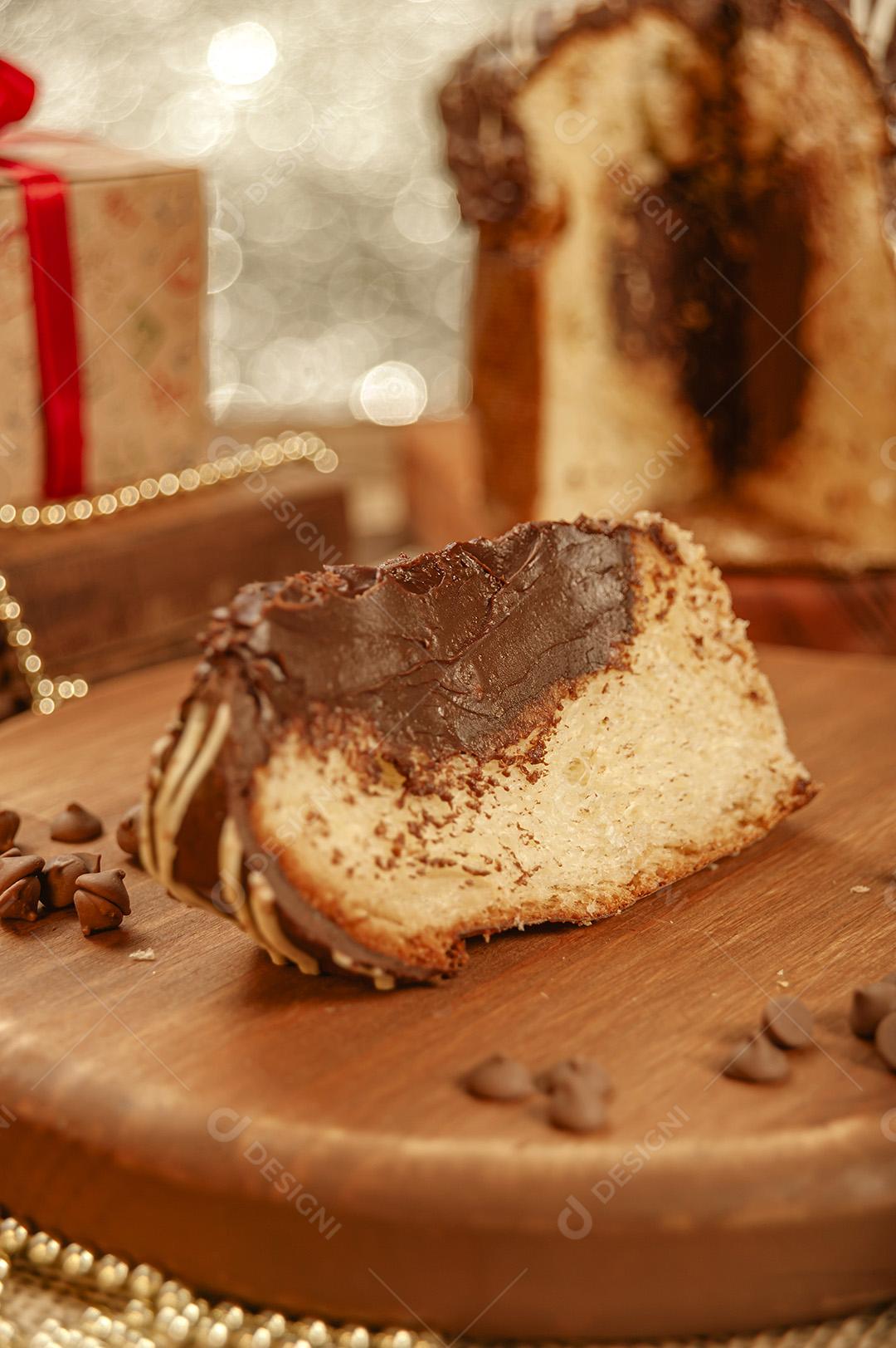 Fatia de Panetone de Chocolate Em Uma Tábua de Madeira Com Enfeites de Natal Imagem JPG