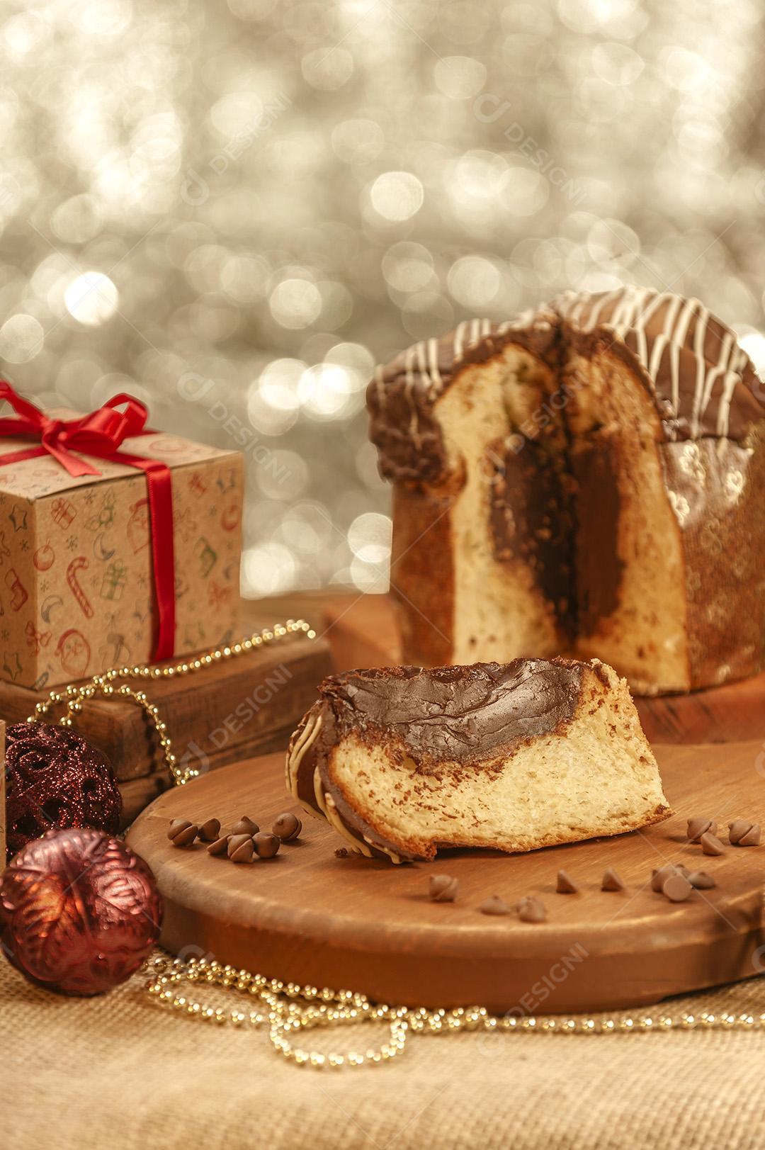 Fatia de Panetone de Chocolate Em Uma Tábua de Madeira Com Enfeites de Natal Imagem JPG