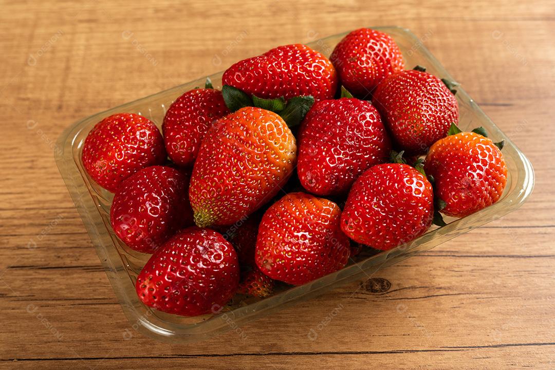 Morangos Em Um Prato De Plástico Sobre Uma Mesa De Madeira E Fundo Cinza